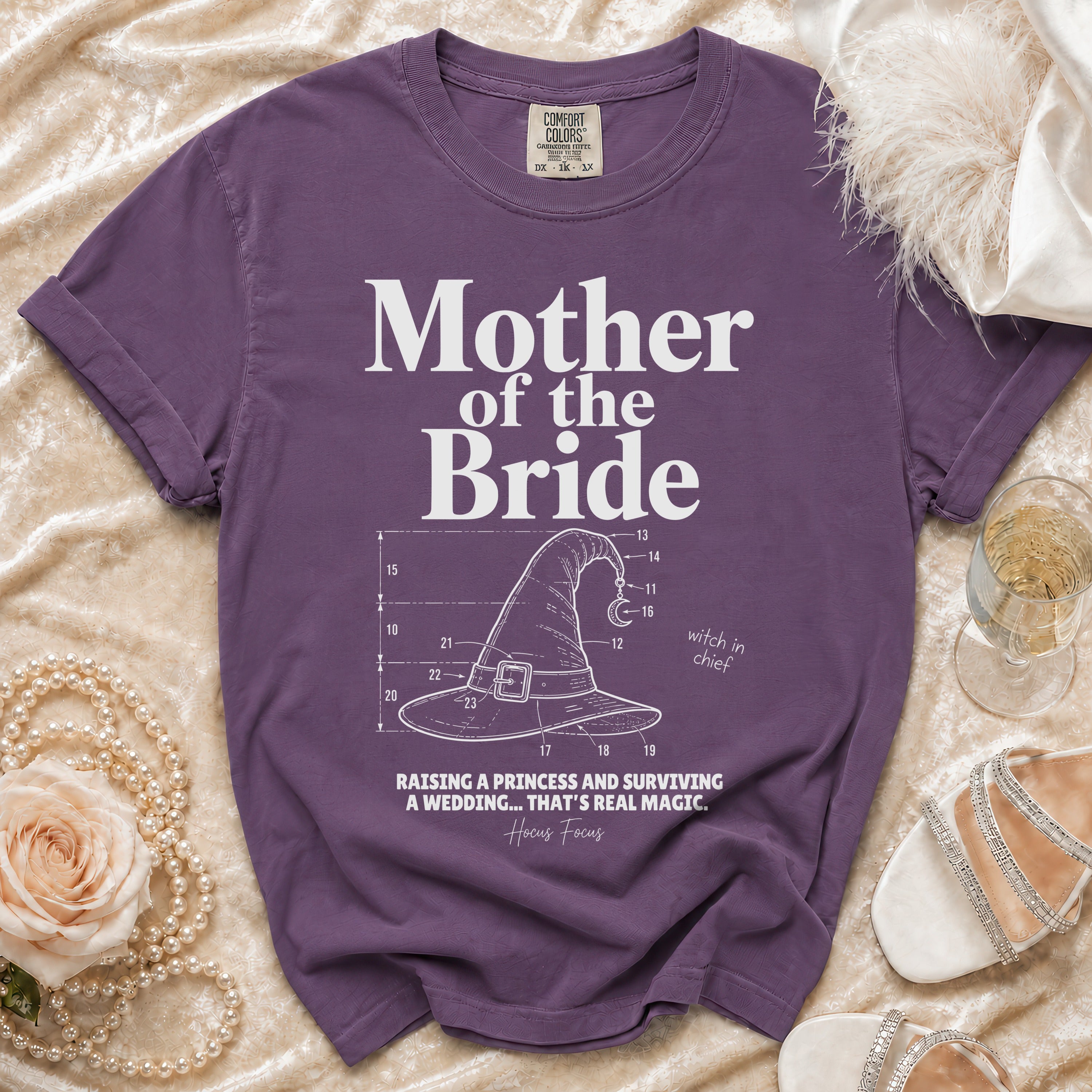 Purple Comfort Colors shirt with "Mother of the Bride" text and witch hat graphic.