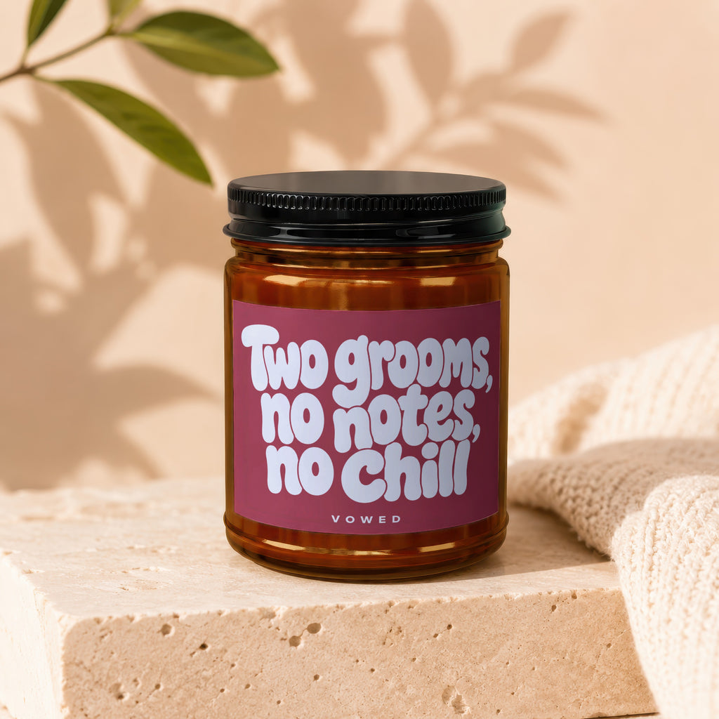 Amber candle in glass jar with black lid, label reads "Two grooms, no notes, no chill VOWED".