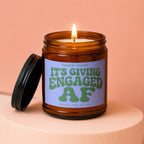 Amber jar candle with lit wick and "CURRENT STATUS: IT'S GIVING ENGAGED AF" text.