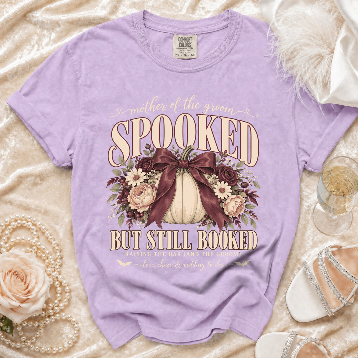 Purple t-shirt with "mother of the groom SPOOKED BUT STILL BOOKED" graphic.
