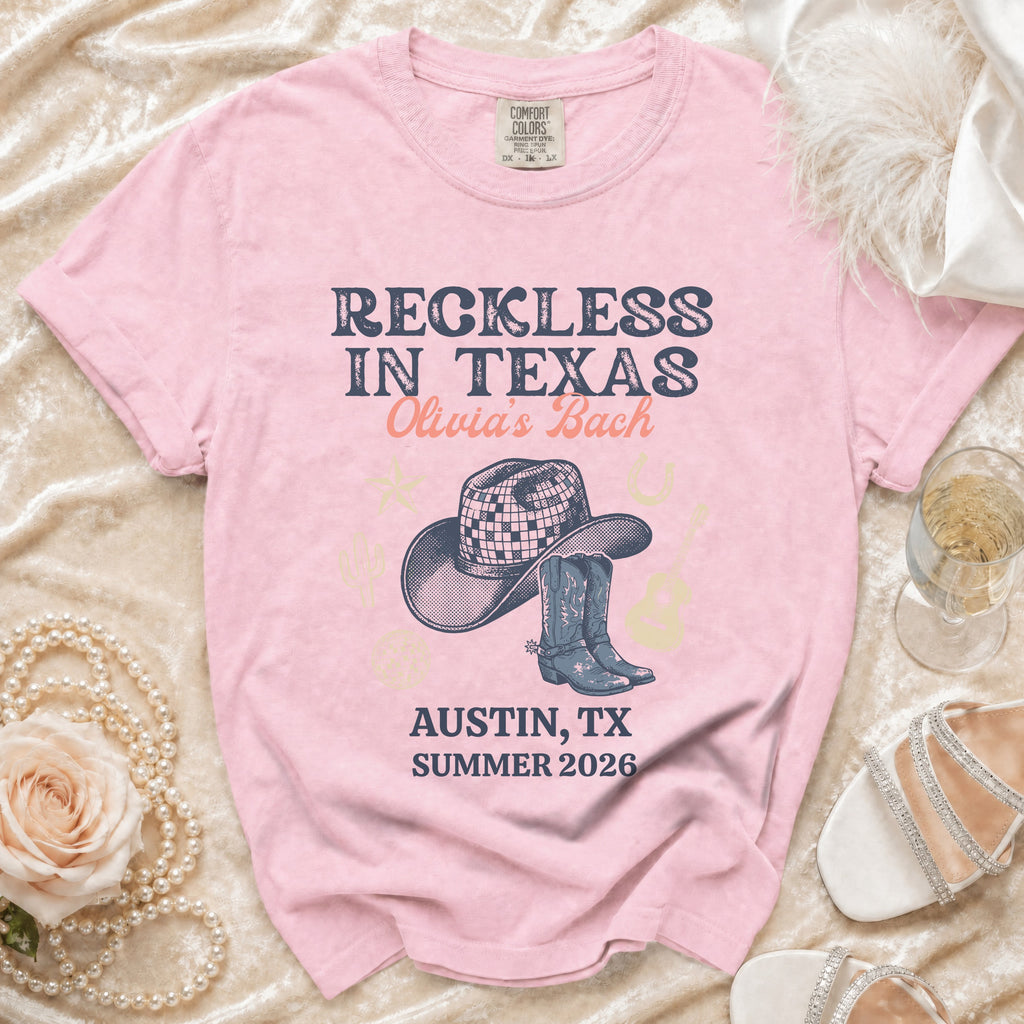 Pink t-shirt with "Reckless in Texas Olivia's Bach" and cowboy hat graphic.