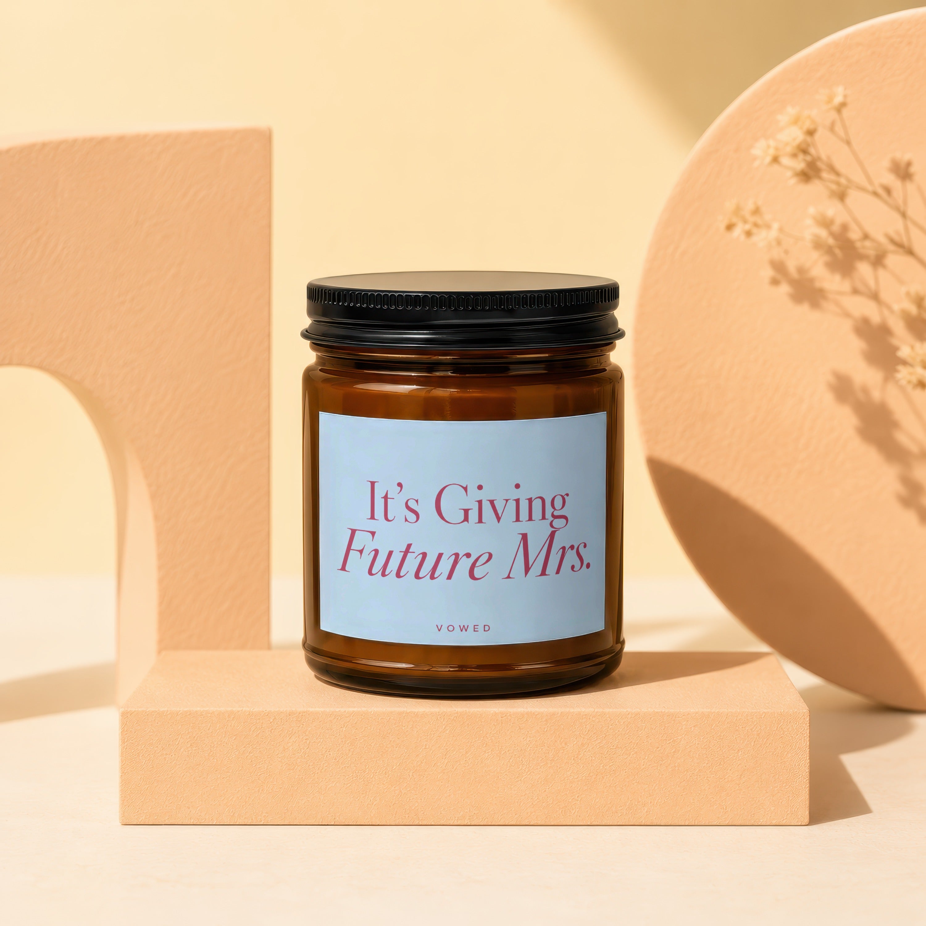 Amber candle with black lid and "It's Giving Future Mrs." label.