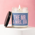 Glass candle with lit wick and lid, reads "The Mr. & Mrs. Era".