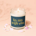 Candle with lit wick, teal label reading "In my wife era. VOWED."