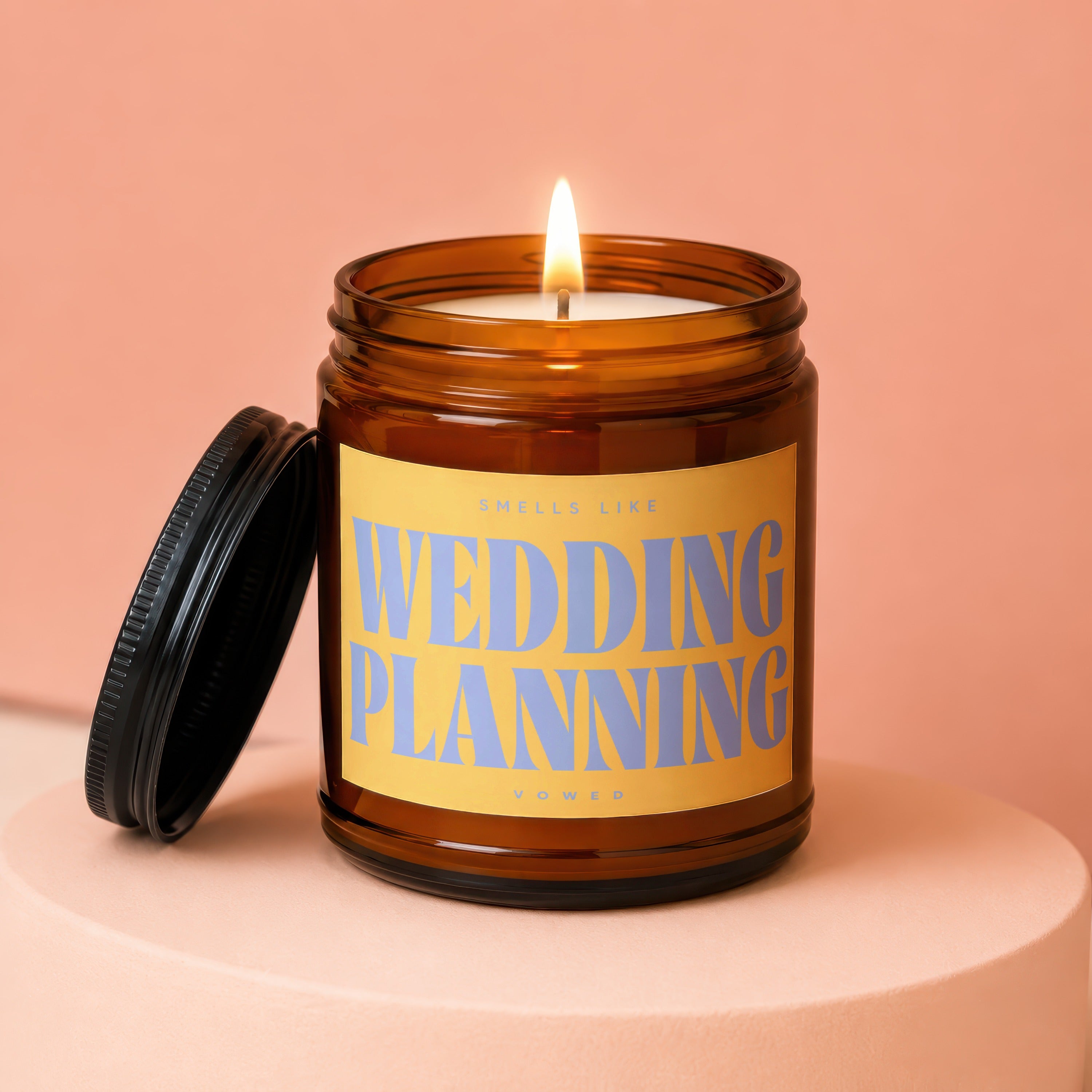 Amber jar candle with lit wick and "Smells Like Wedding Planning" text.