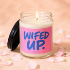 Candle with "WIFED UP" text on a pink label, surrounded by petals.