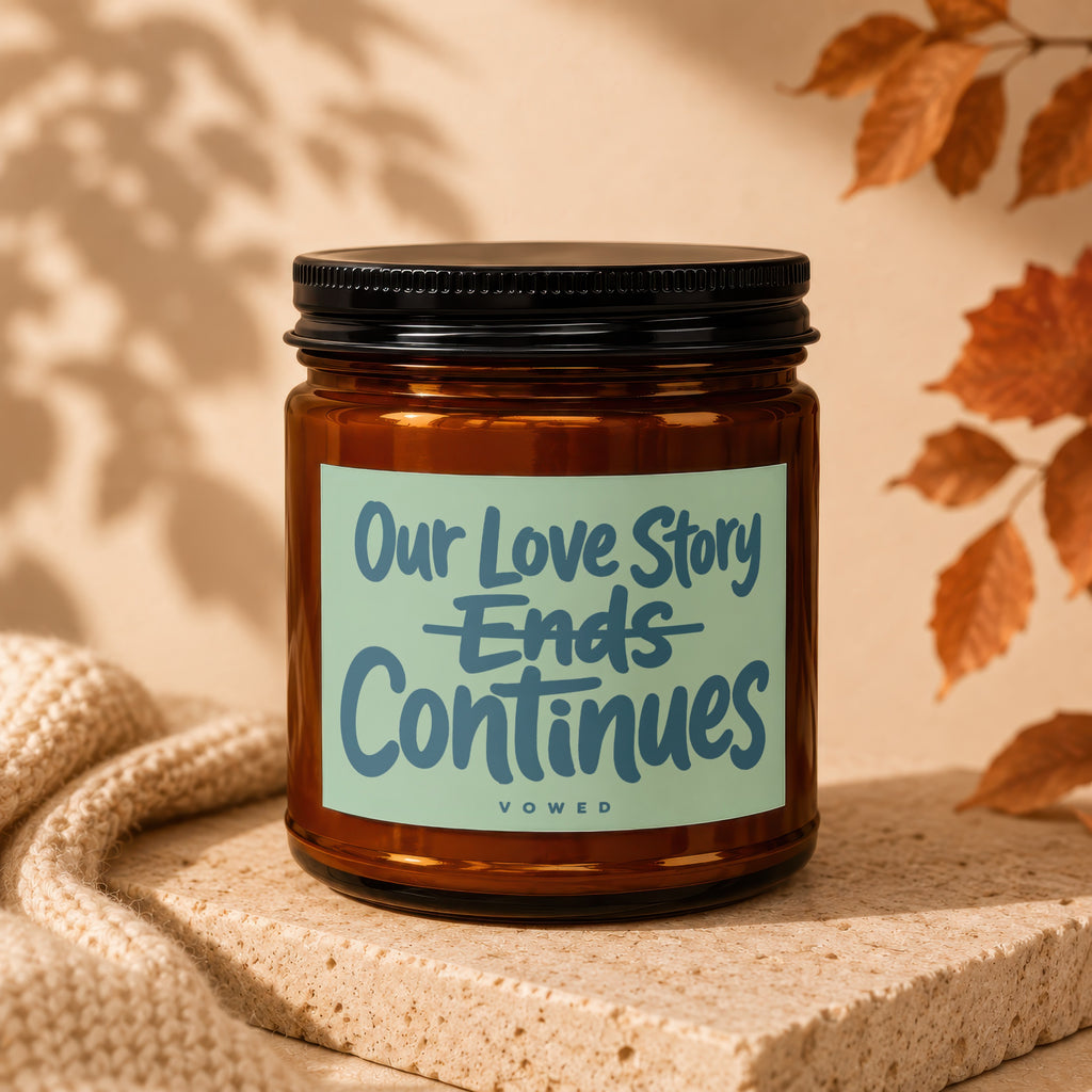 Candle with text "Our Love Story Ends Continues VOWED" on a beige background.