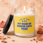 Glass candle with yellow label reading "Light me when my maid of honor says yes!".