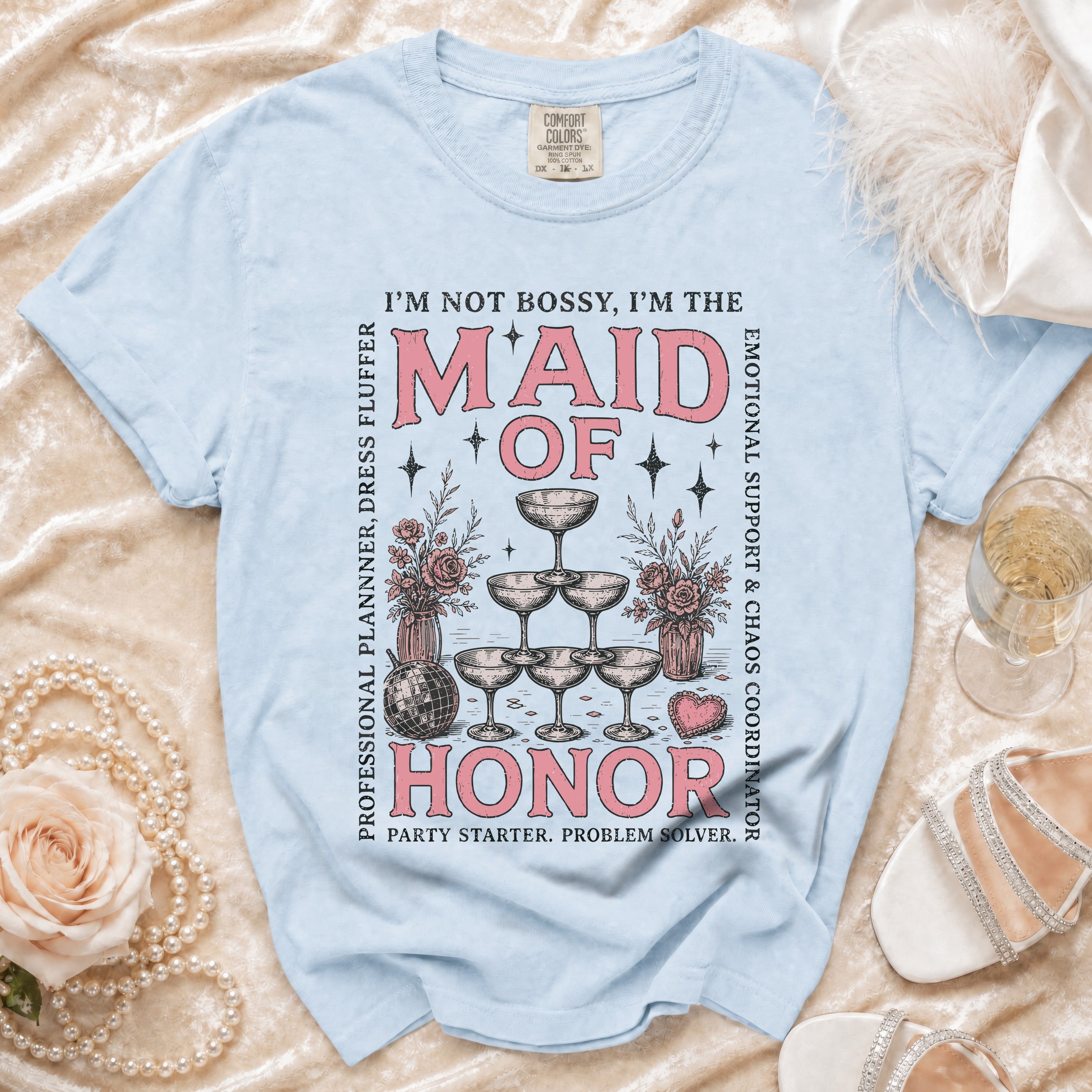 Light blue t-shirt with "Maid of Honor" text and graphics, surrounded by wedding-themed elements.