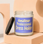 Glass candle with blue label reading "Amateur Professional Dress Holder".