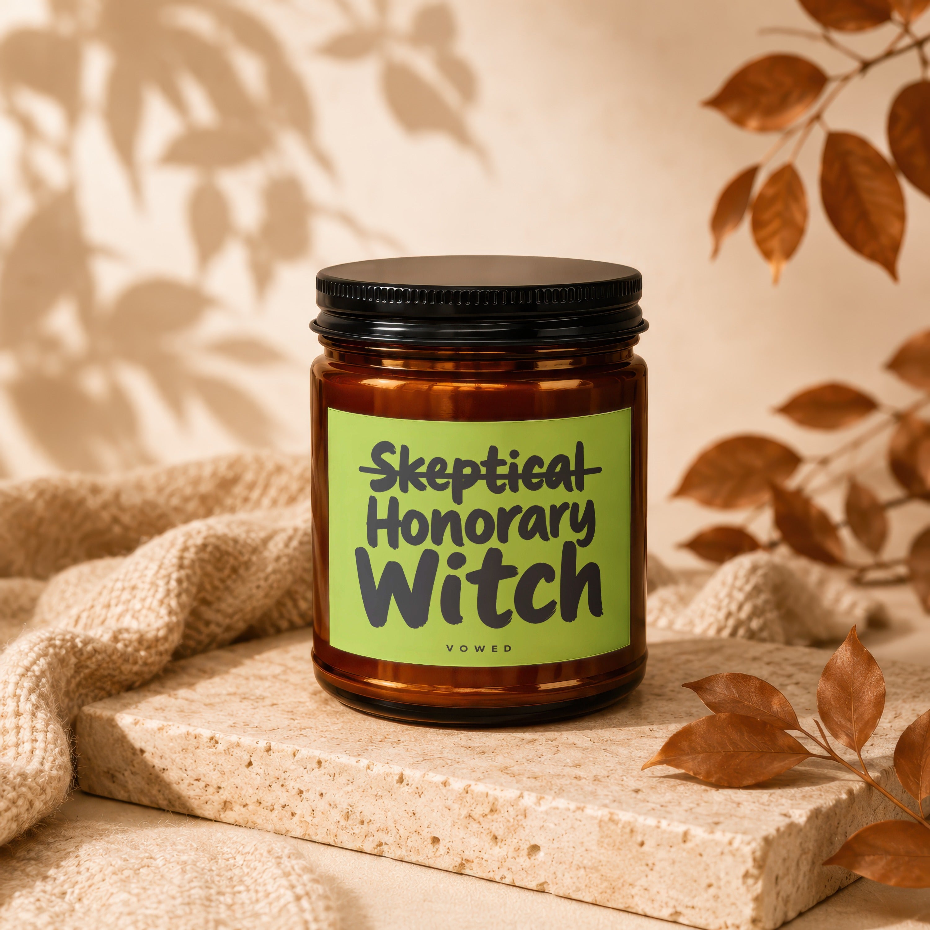 Amber candle with "Skeptical Honorary Witch Vowed" on a green label.