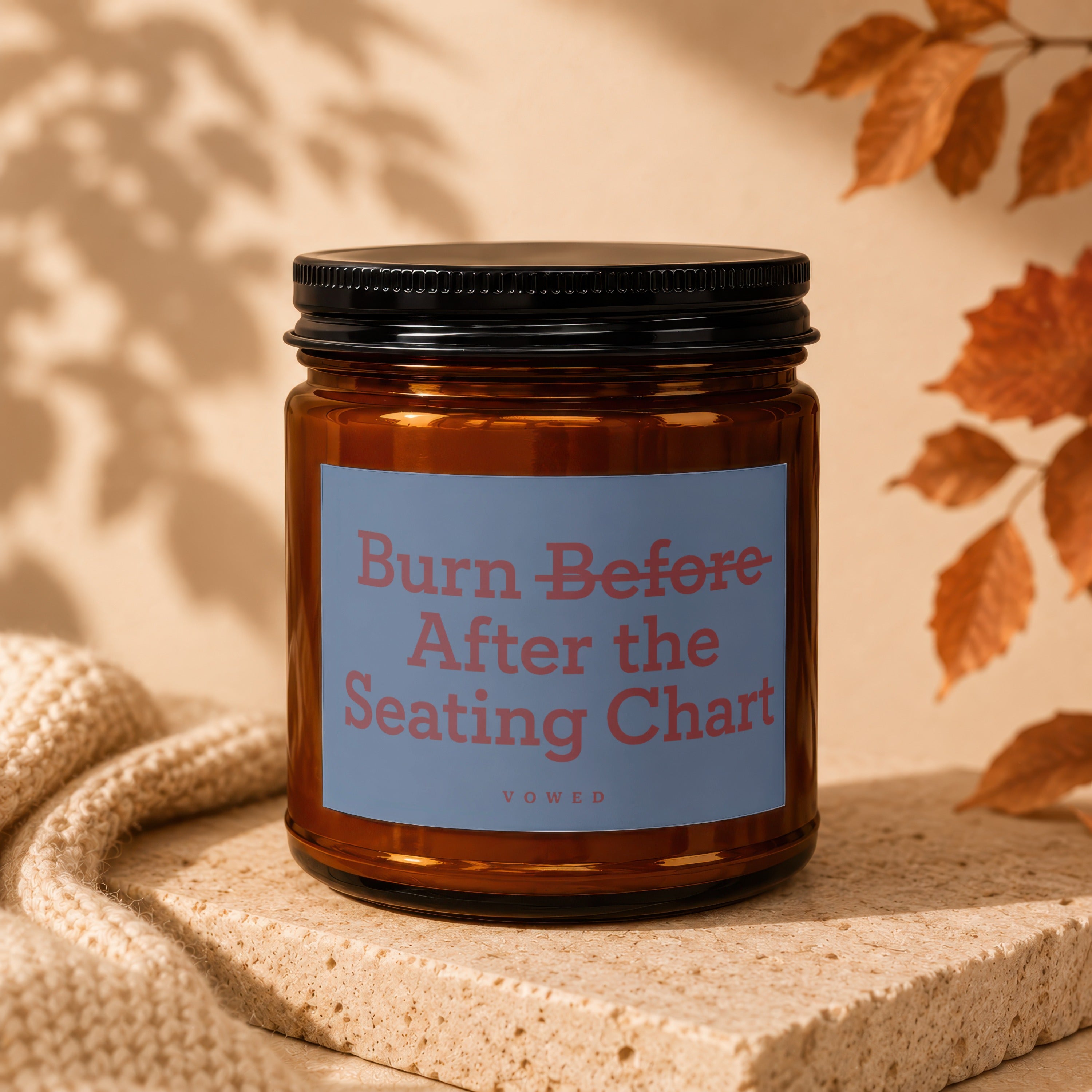 Amber jar candle with a label reading "Burn Before After the Seating Chart Vowed".