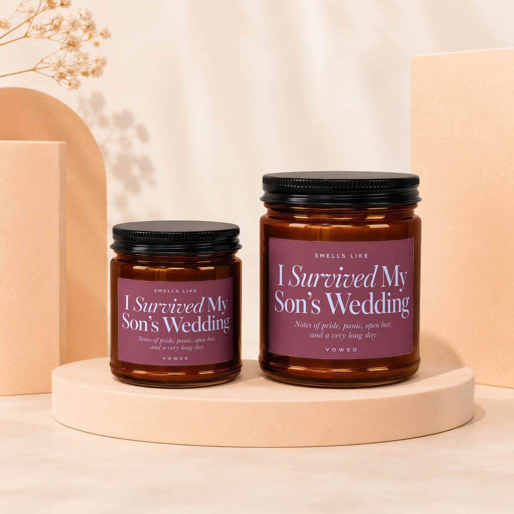 Two amber glass candles with "I Survived My Son's Wedding" labels.
