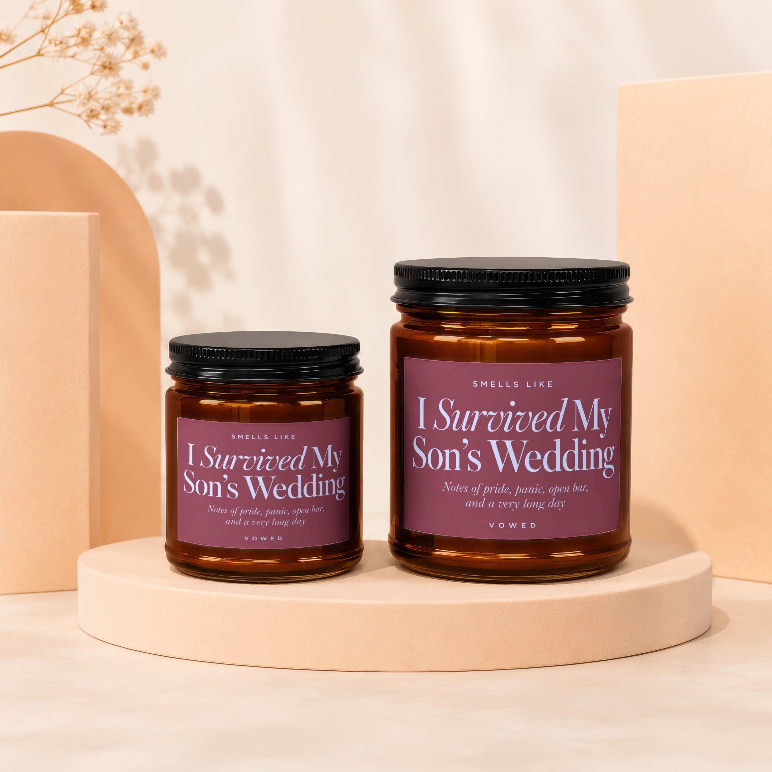 Two amber glass candles with "I Survived My Son's Wedding" labels.