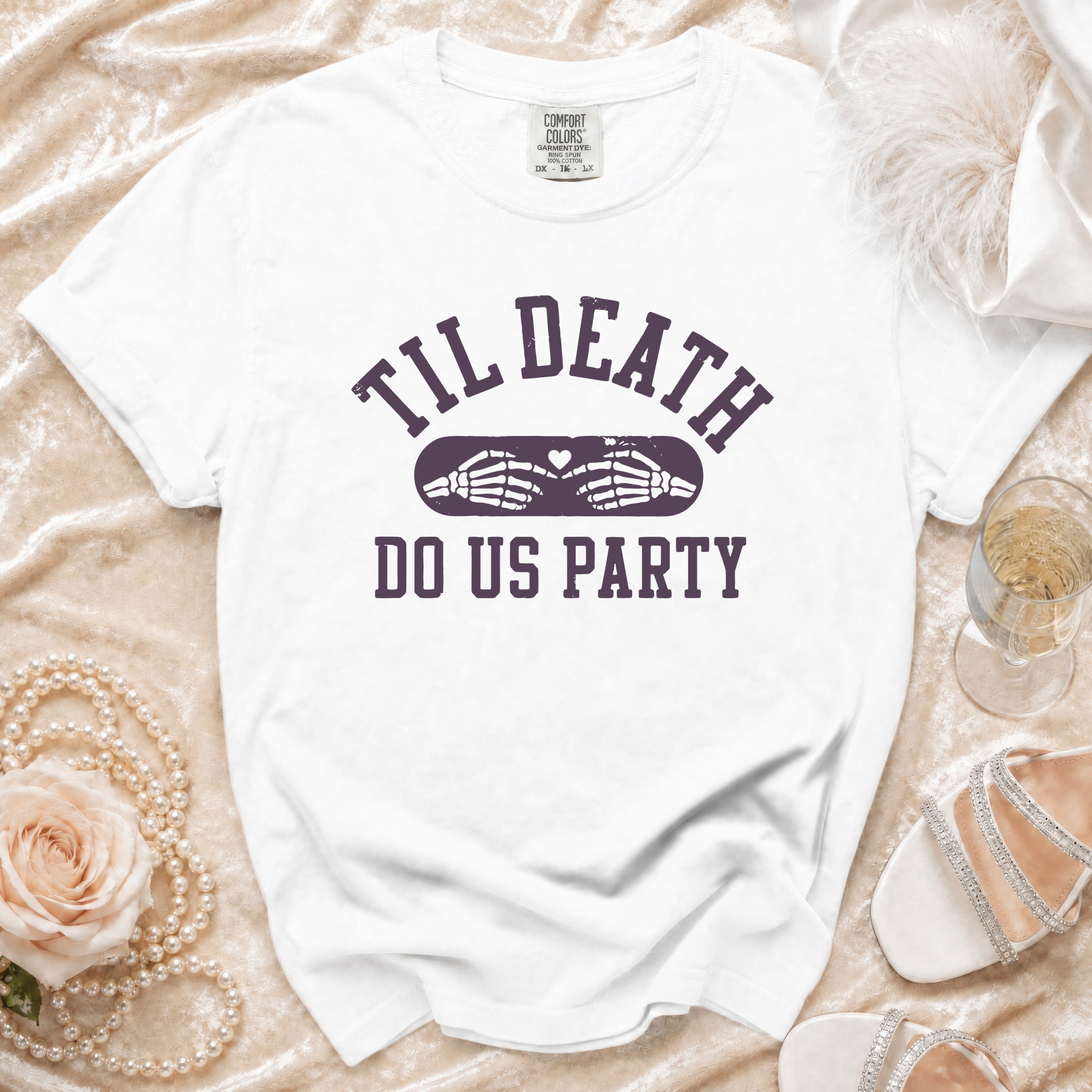 White t-shirt with "Til Death Do Us Party" text and skeleton hands forming a heart.