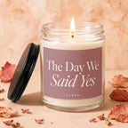 Glass candle labeled "The Day We Said Yes" with a lit flame.