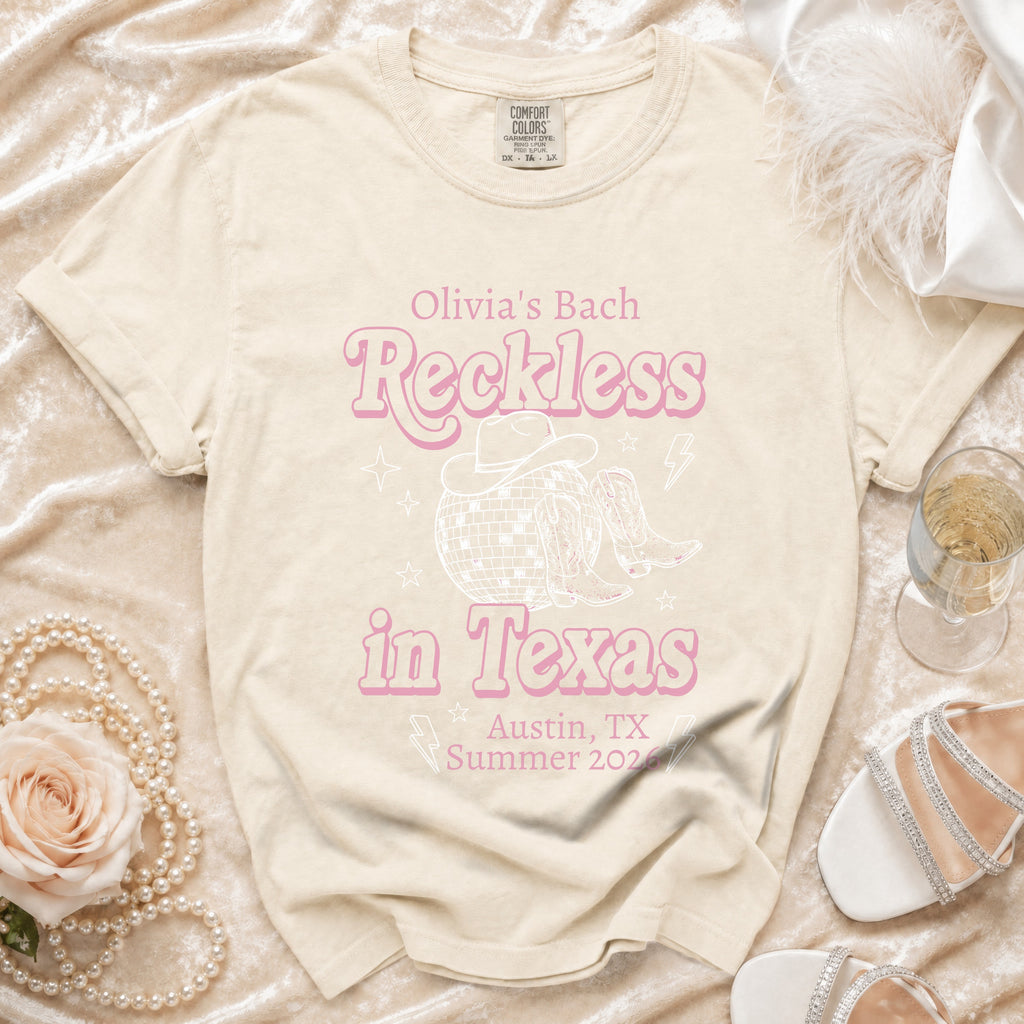Cream t-shirt with pink graphic "Olivia's Bach Reckless in Texas Austin, TX Summer 2026".