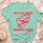 Pink cowboy hat and bandana graphic on a teal "Her Last Rodeo Jennifer's Bach" t-shirt.
