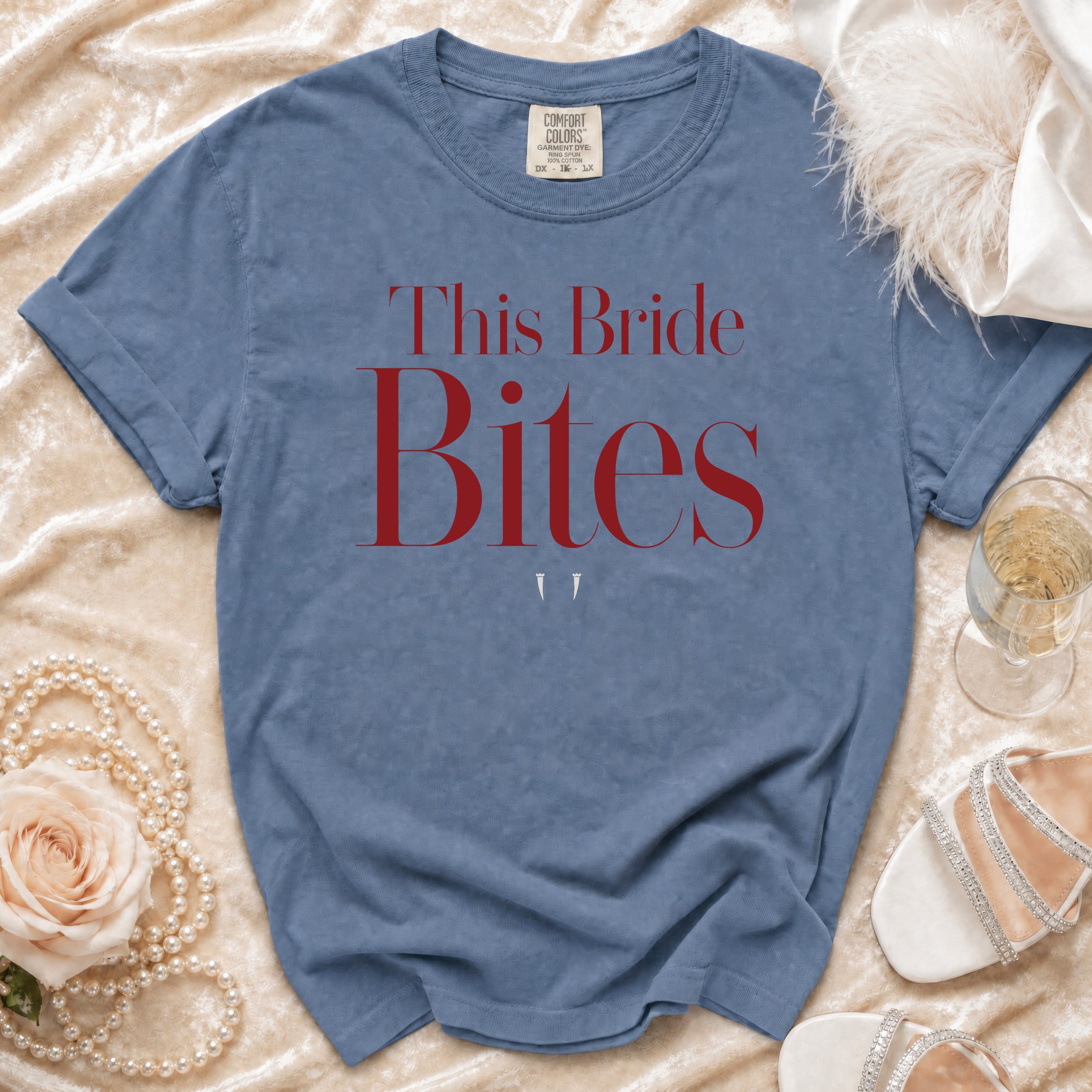 Blue t-shirt with red text "This Bride Bites" and two fangs.