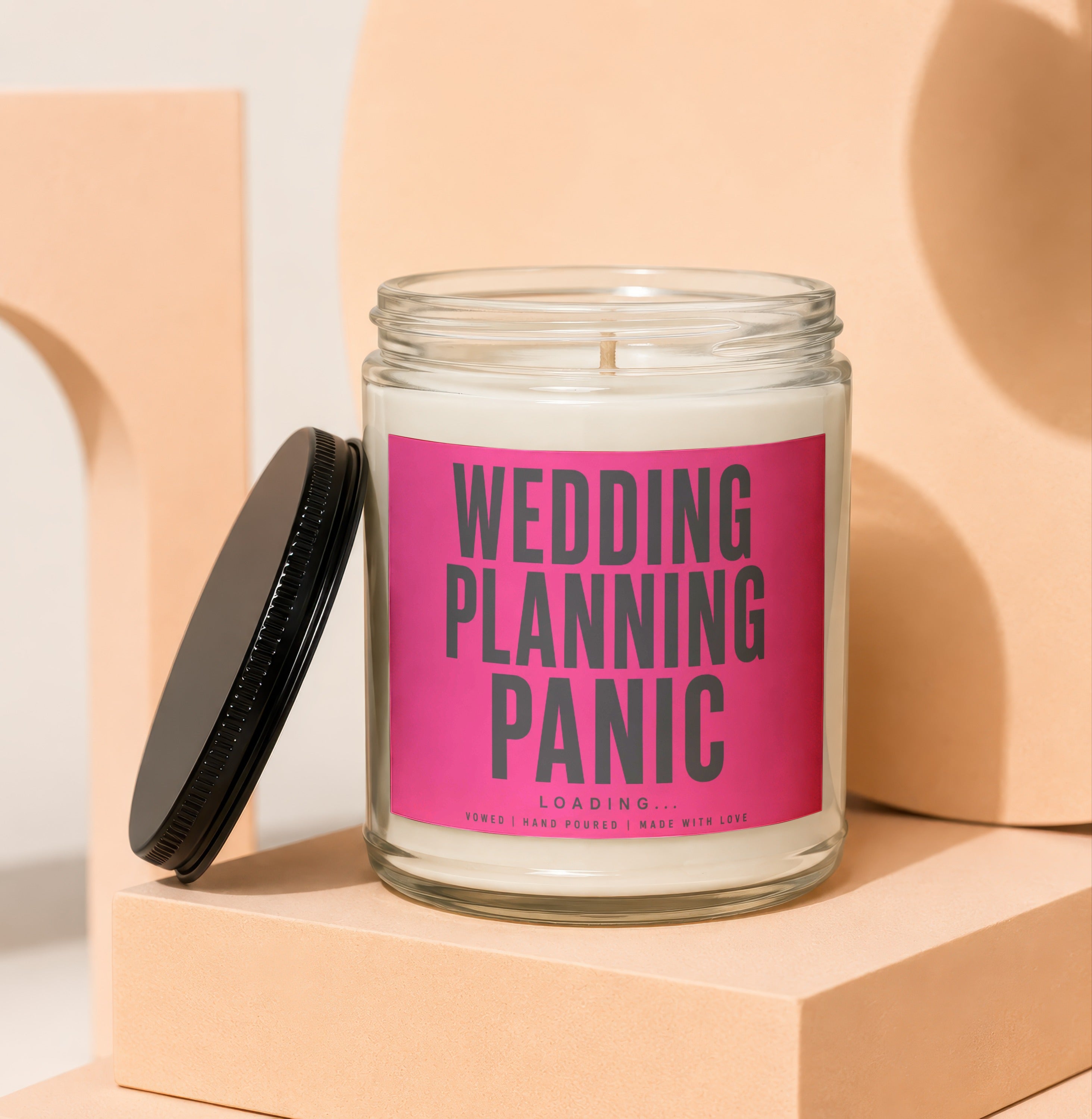 Candle with "WEDDING PLANNING PANIC LOADING..." text on pink label.