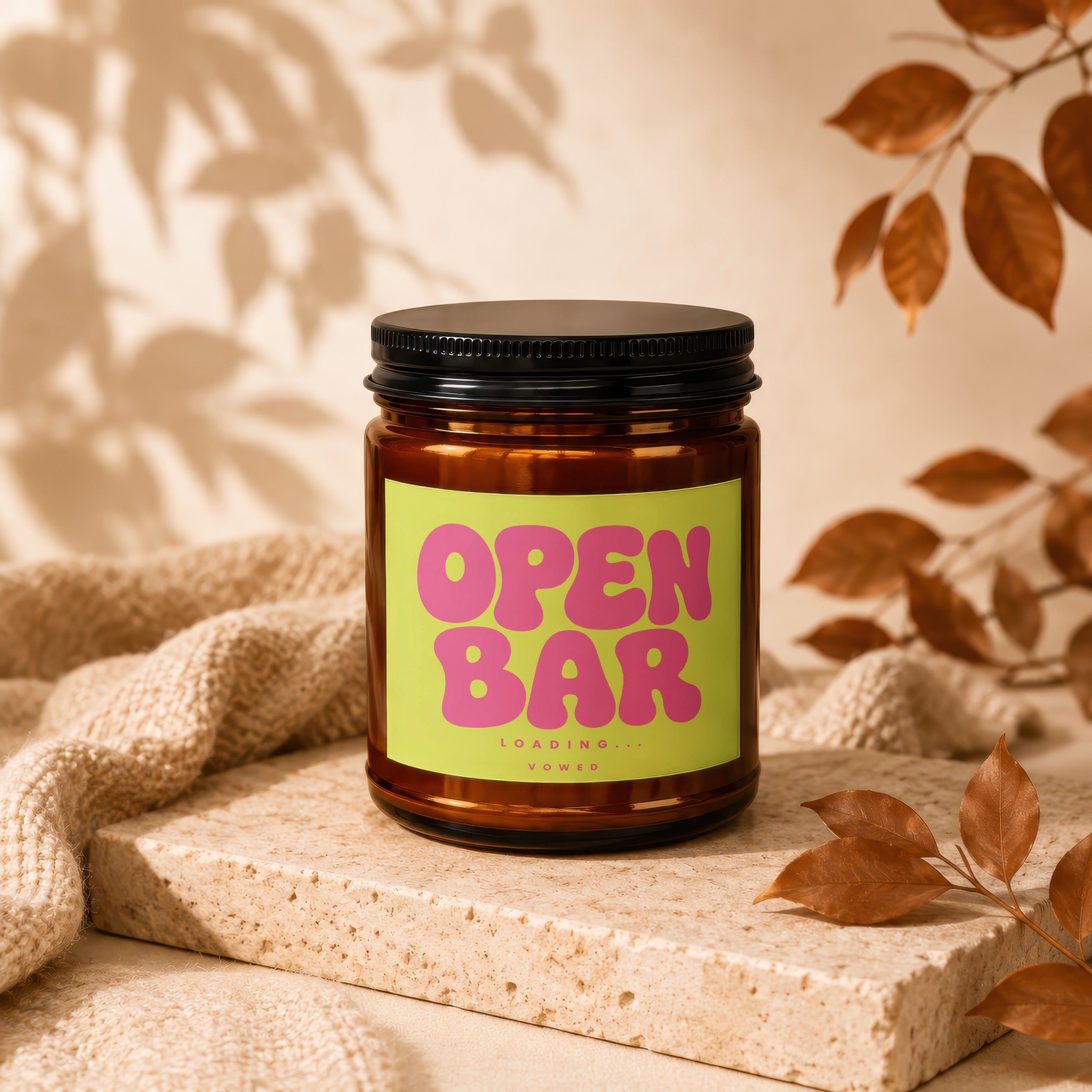 Amber jar candle with neon green label reading "OPEN BAR LOADING... VOWED".