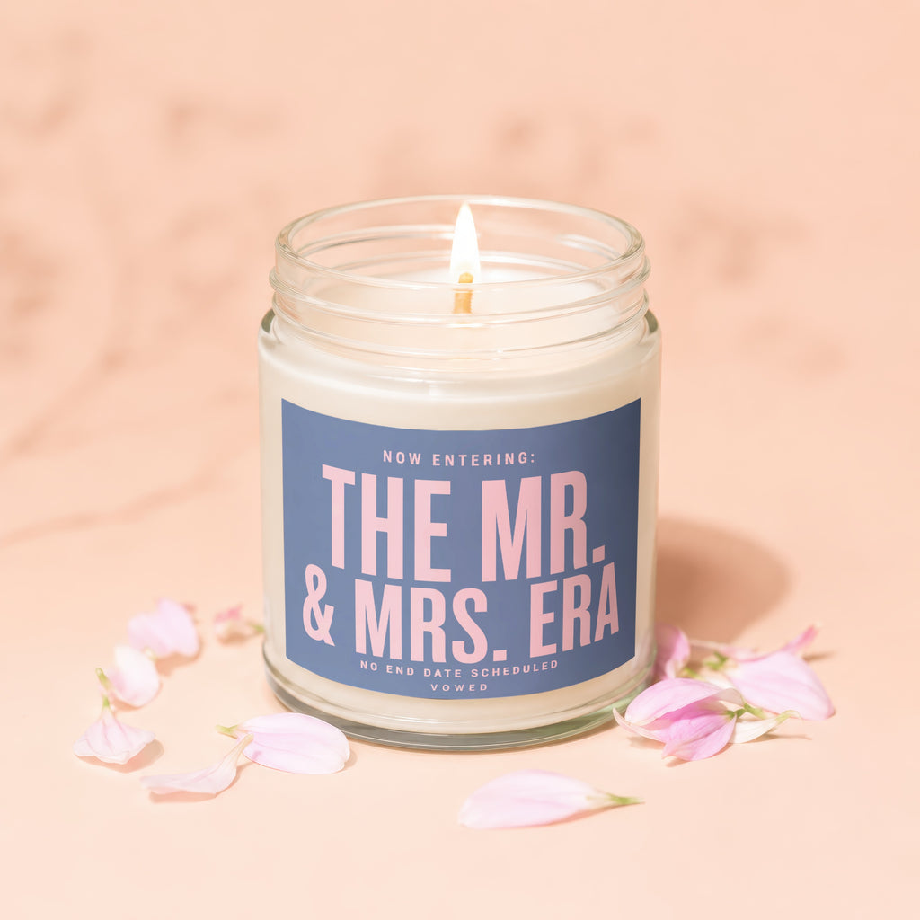 Candle with text "The Mr. & Mrs. Era" surrounded by pink petals.