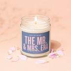Candle with text "The Mr. & Mrs. Era" surrounded by pink petals.