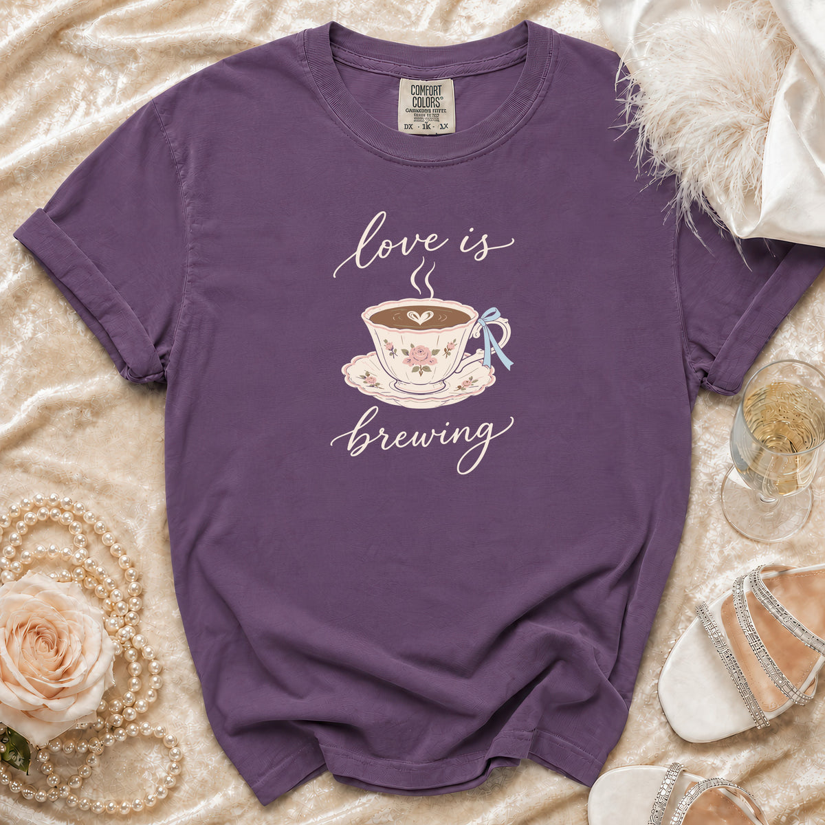 Purple t-shirt with "love is brewing" text and a teacup graphic.