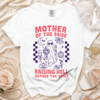 White t-shirt with "Mother of the Bride Raising Hell Before the Vows" graphic.