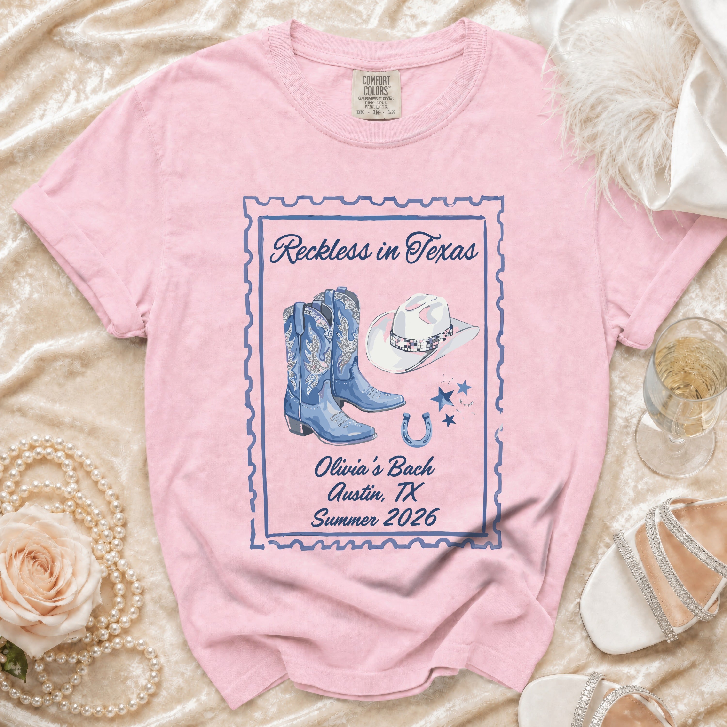 Pink t-shirt with "Reckless in Texas" and Western graphics.