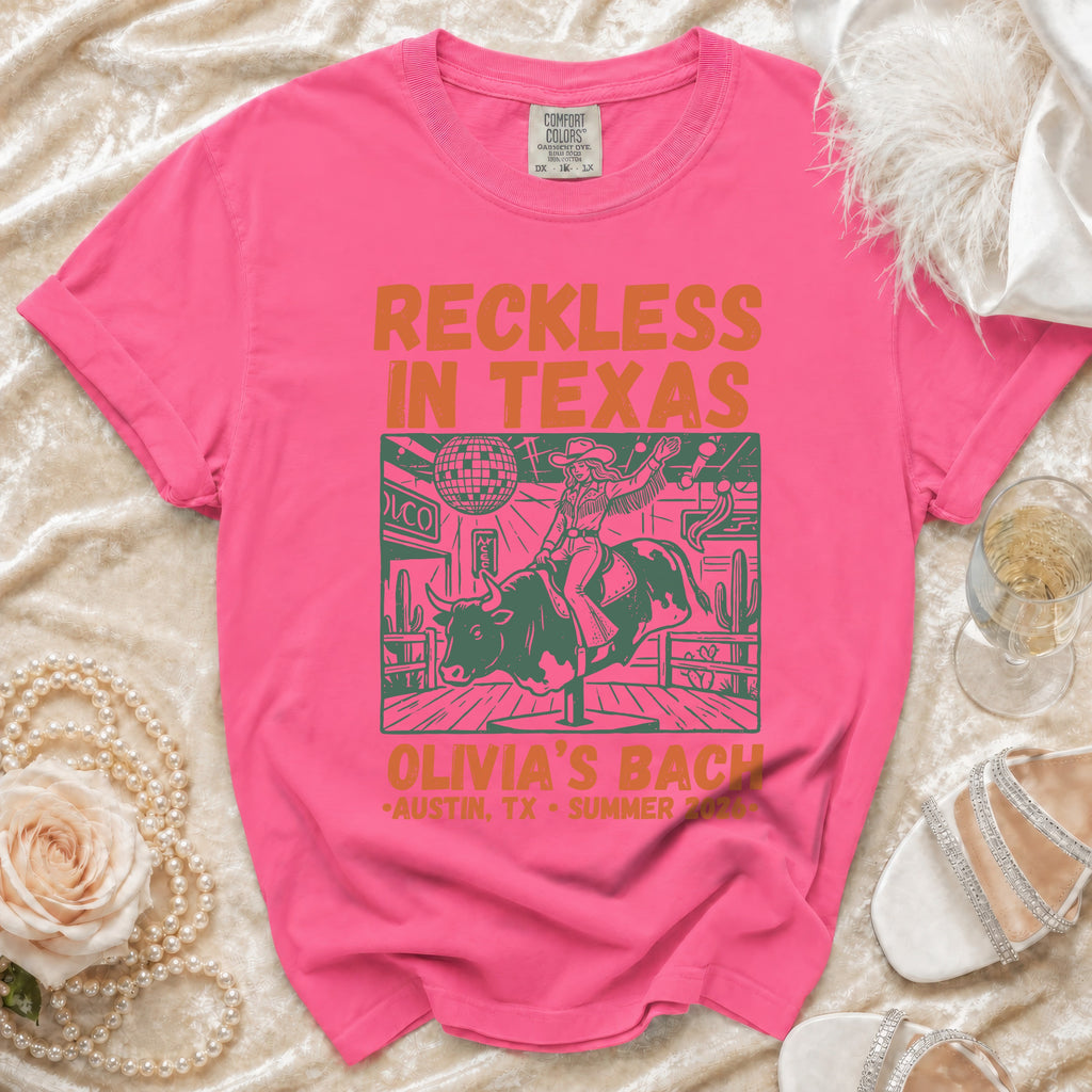 Graphic t-shirt with "Reckless in Texas" and bull rider design.