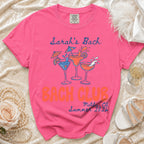 Bright pink t-shirt with "Sarah's Bach", "Bach Club", "Malibu, CA", and "Summer 2026" text.