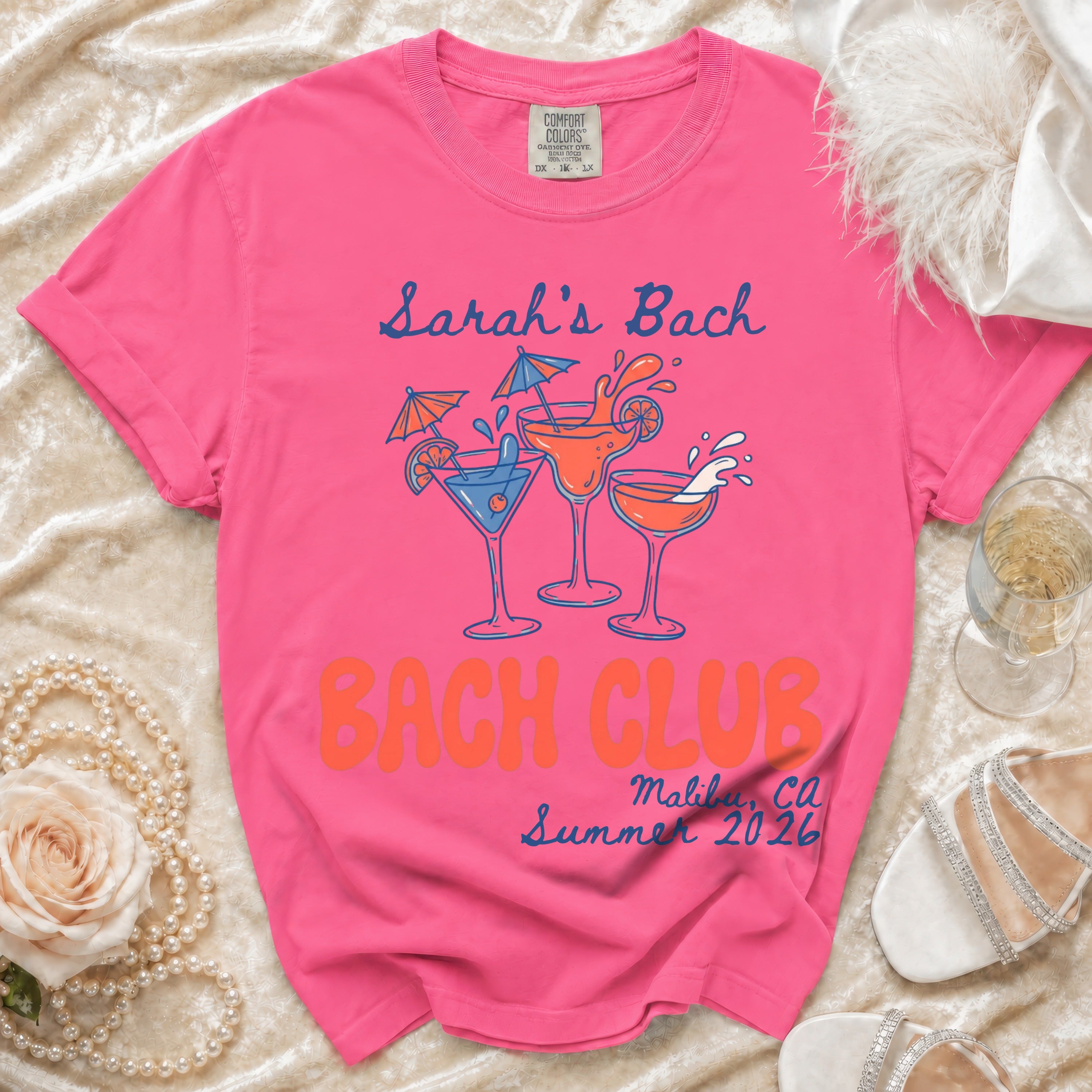 Bright pink t-shirt with "Sarah's Bach", "Bach Club", "Malibu, CA", and "Summer 2026" text.
