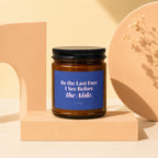 Amber candle with a blue label that reads "Be the Last Face I See Before the Aisle."