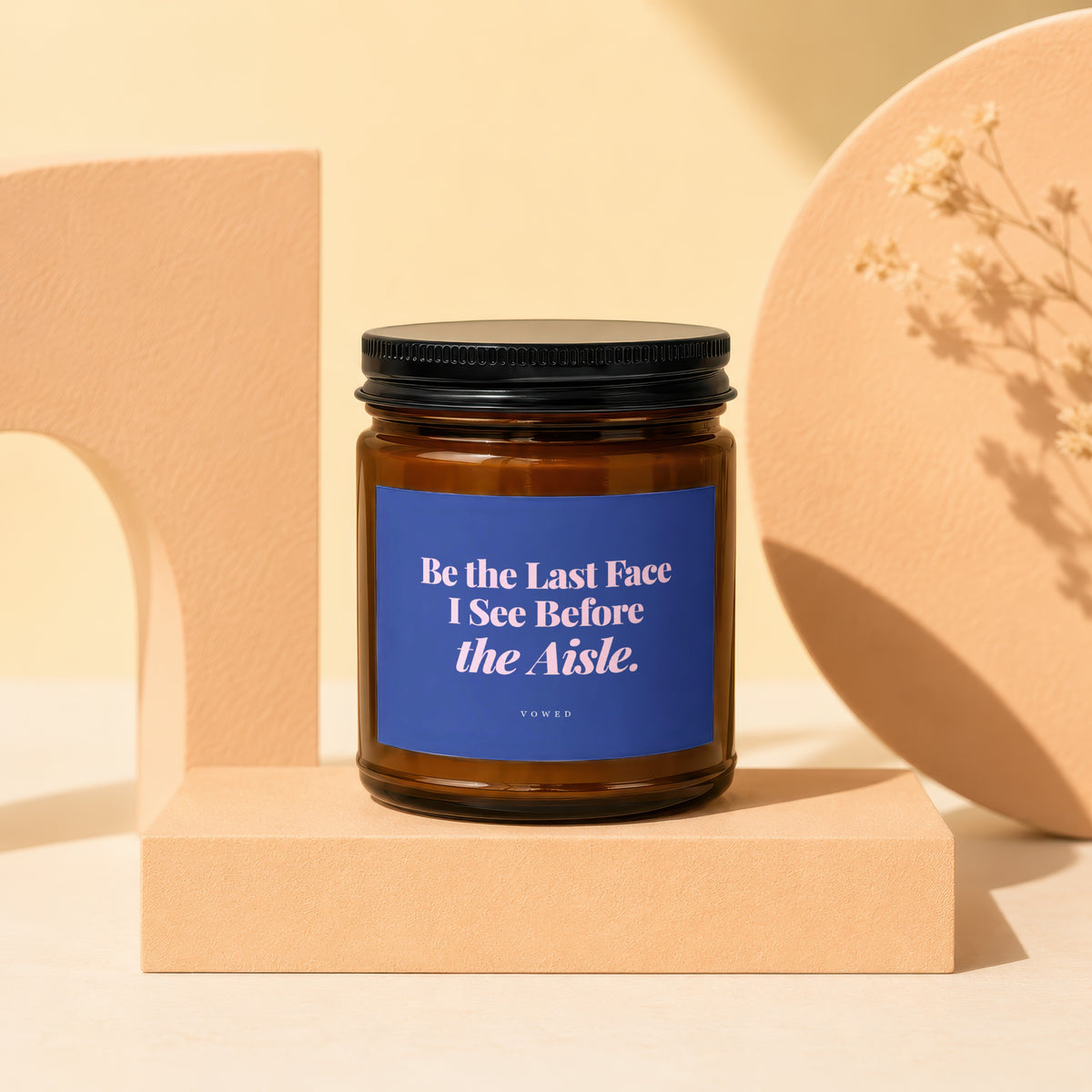 Amber candle with a blue label that reads "Be the Last Face I See Before the Aisle."