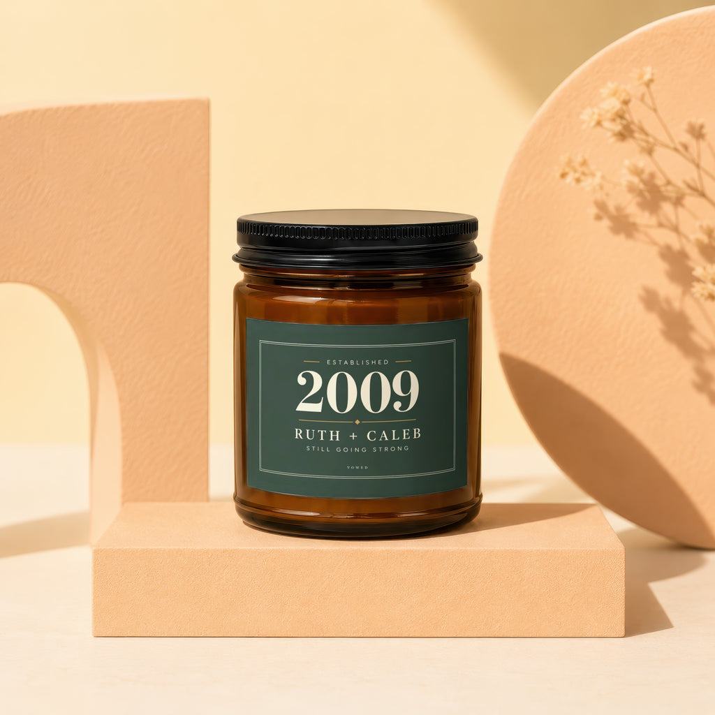 Brown glass candle with dark green label: "Established 2009 Ruth + Caleb Still Going Strong"