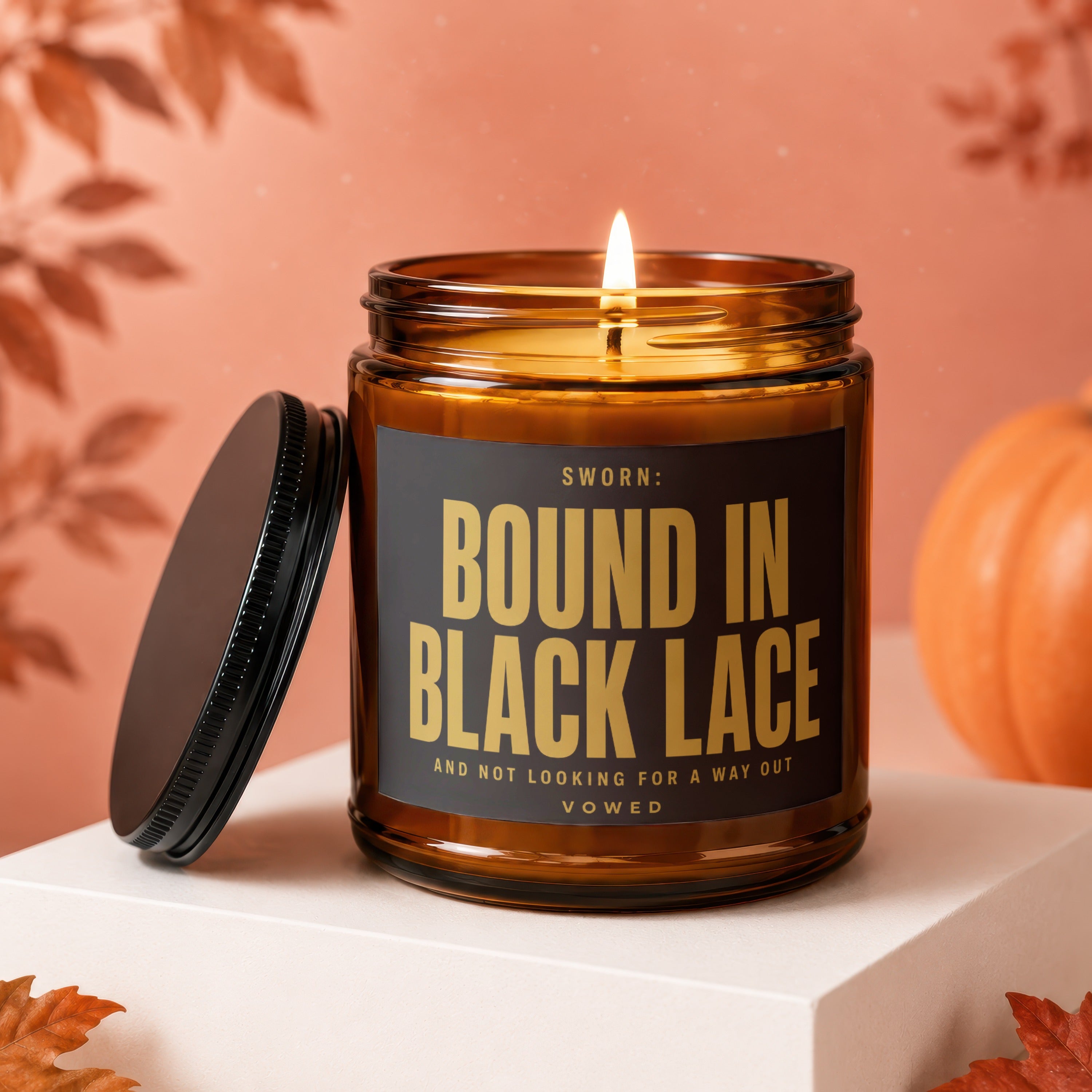 Amber jar candle with lit wick, black lid, text "SWORN: BOUND IN BLACK LACE".