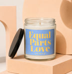 Candle with "Equal Parts Love" and "VOWED" text on a blue label.