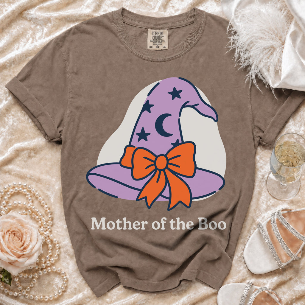 Brown t-shirt with a graphic of a purple witch hat with stars and a moon, and the text "Mother of the Boo."