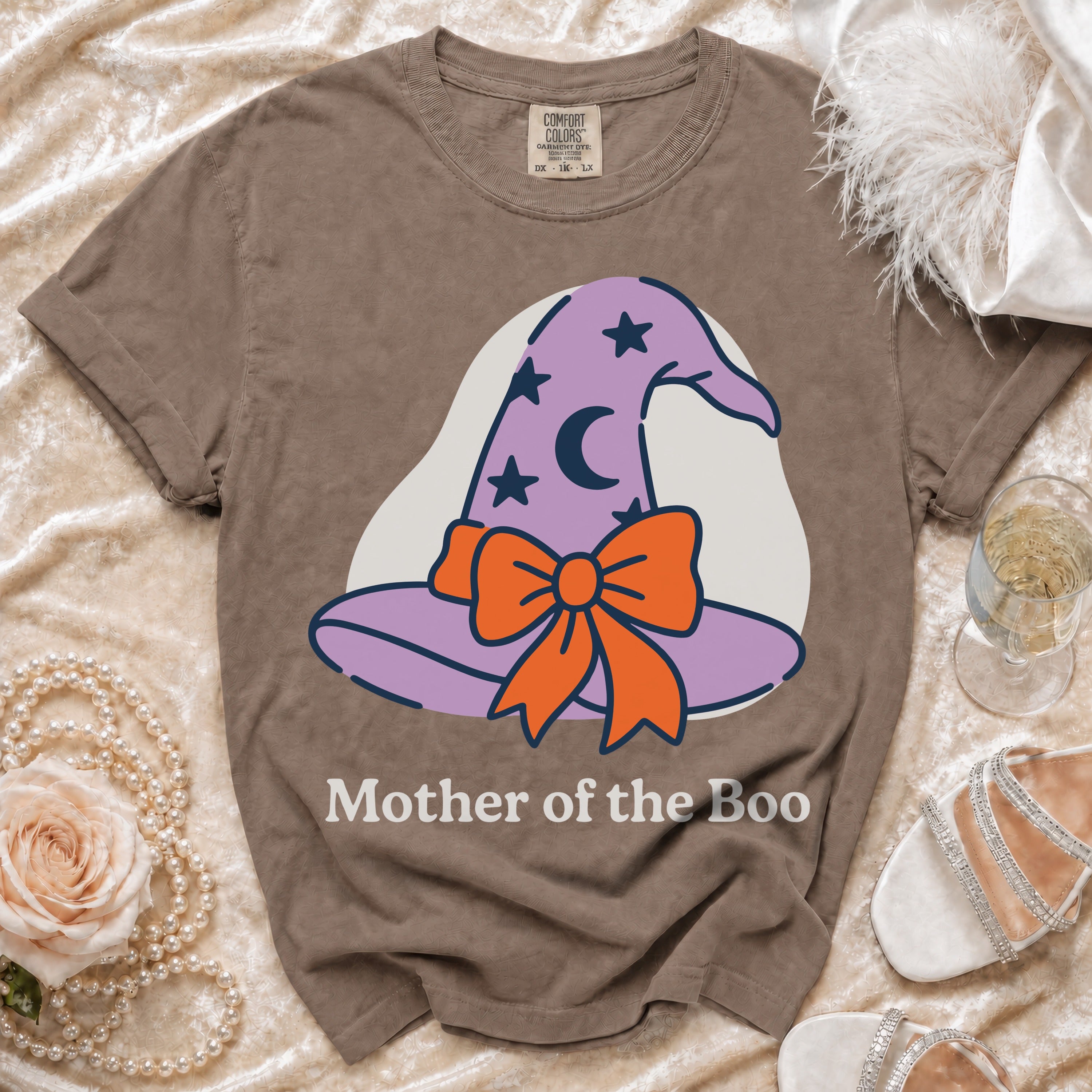 Brown t-shirt with a graphic of a purple witch hat with stars and a moon, and the text "Mother of the Boo."