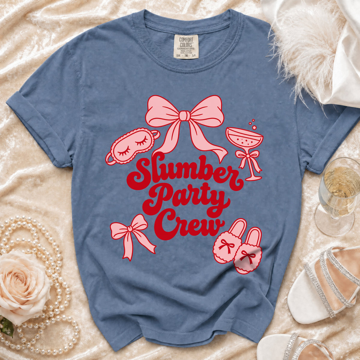 Blue t-shirt with pink and red "Slumber Party Crew" graphic and icons.