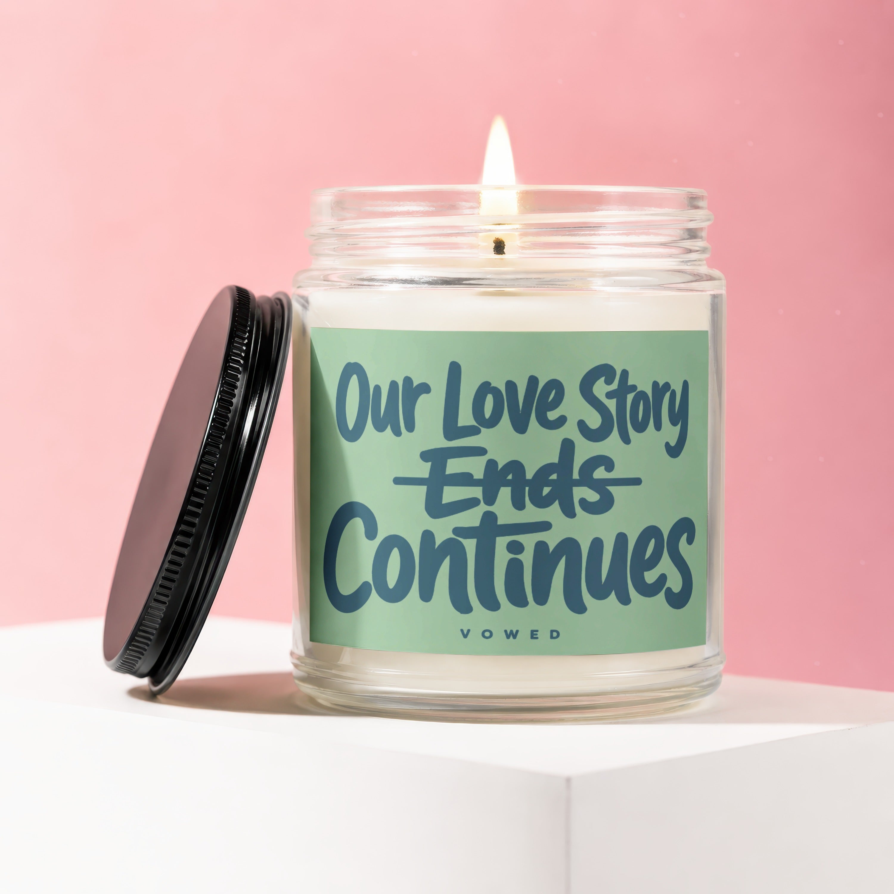 Candle with text "Our Love Story Ends Continues VOWED".