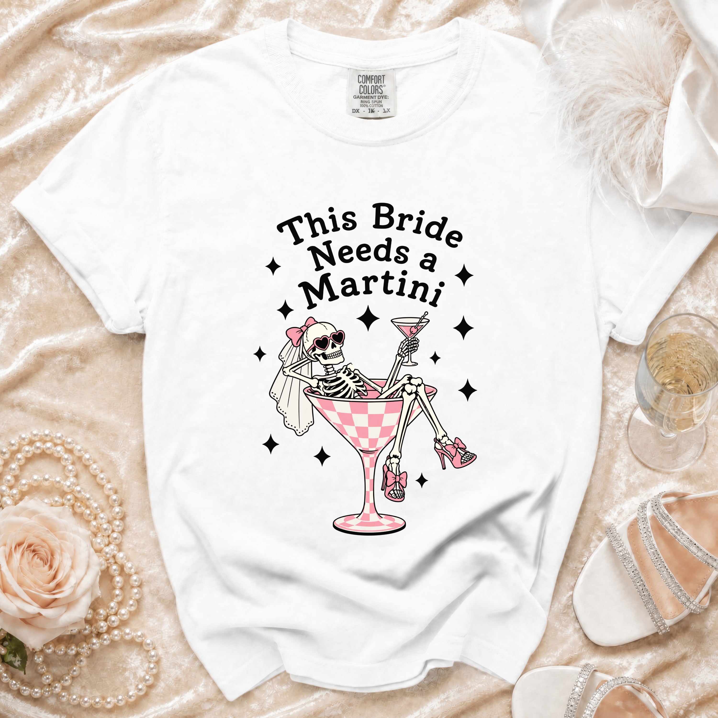 White t-shirt with text "This Bride Needs a Martini" and skeleton bride graphic.