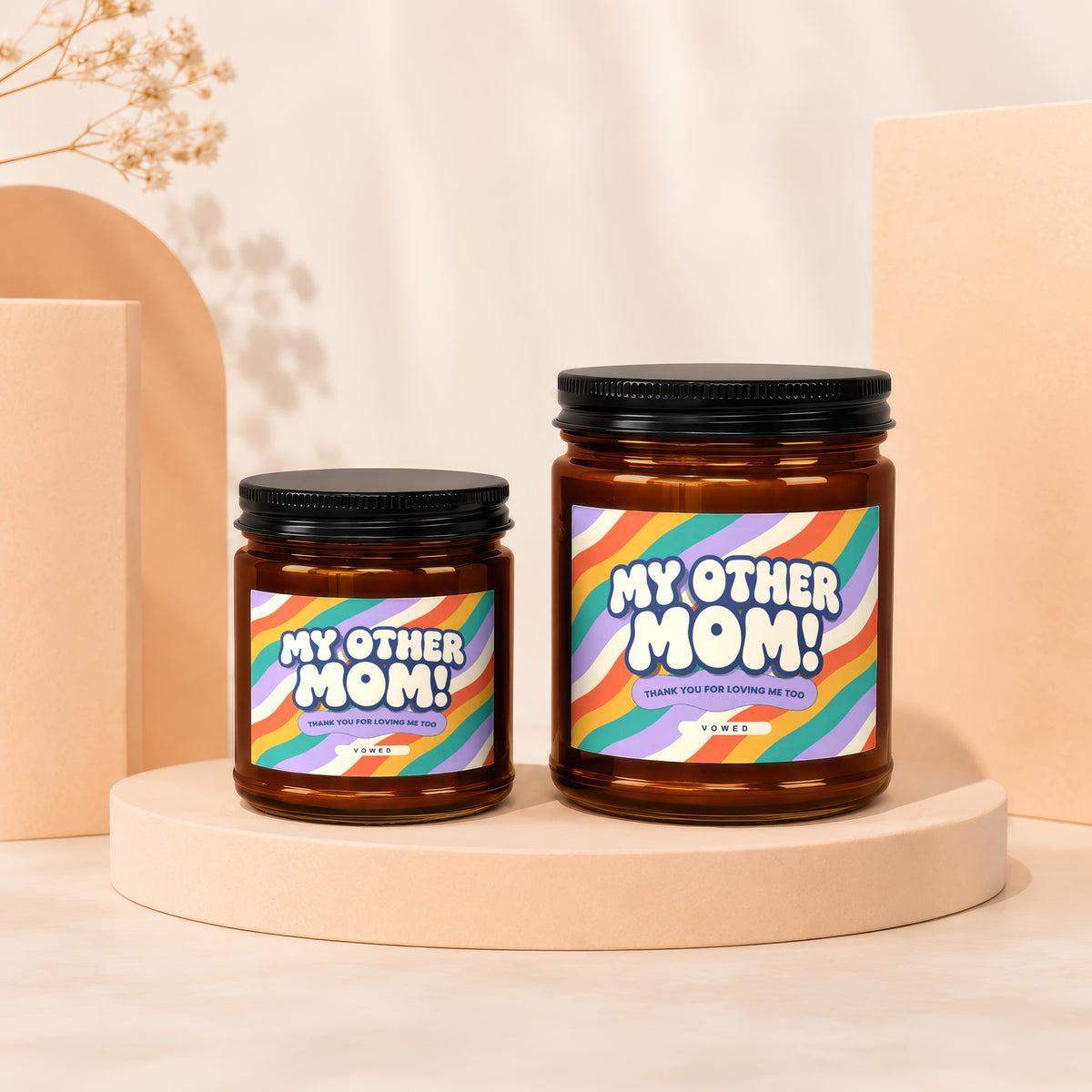 Two amber glass candles with black lids, labeled "My Other Mom!".