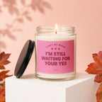 Glass candle with pink label reading "Light me when I'm still waiting for your yes."