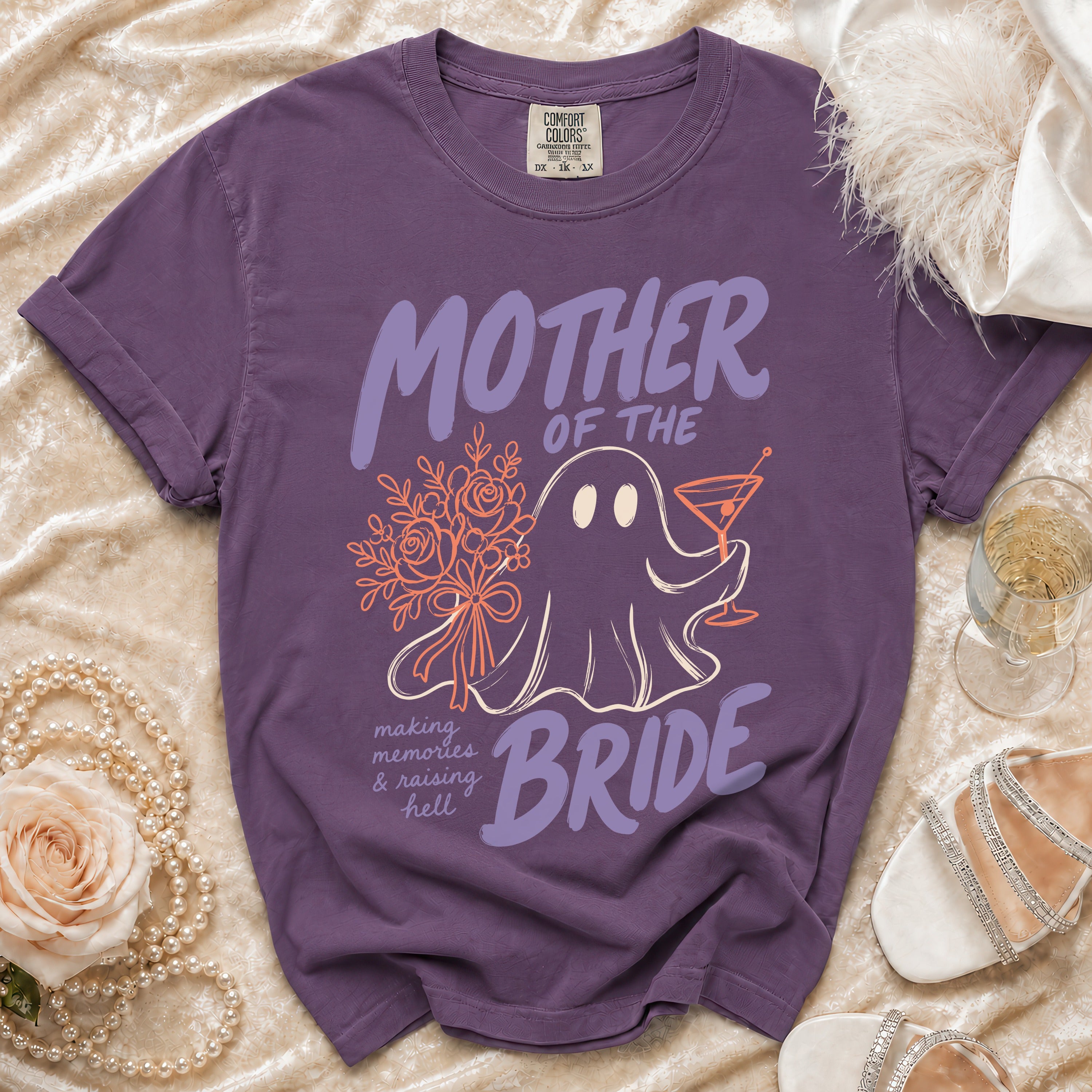 A purple crewneck t-shirt featuring a ghost graphic, holding flowers and a cocktail, with bridal-themed text.