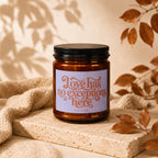 Candle labeled "Love has no exceptions here" by VOWED on a textured surface.