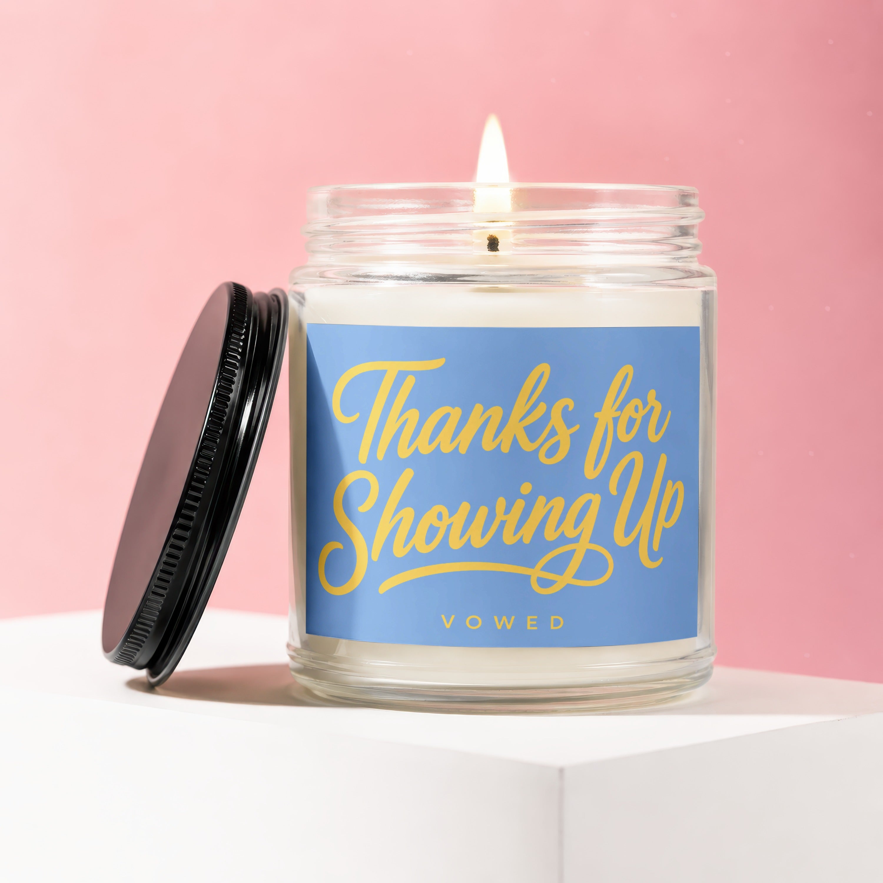 Candle with "Thanks for Showing Up" and "VOWED" text on a blue label
