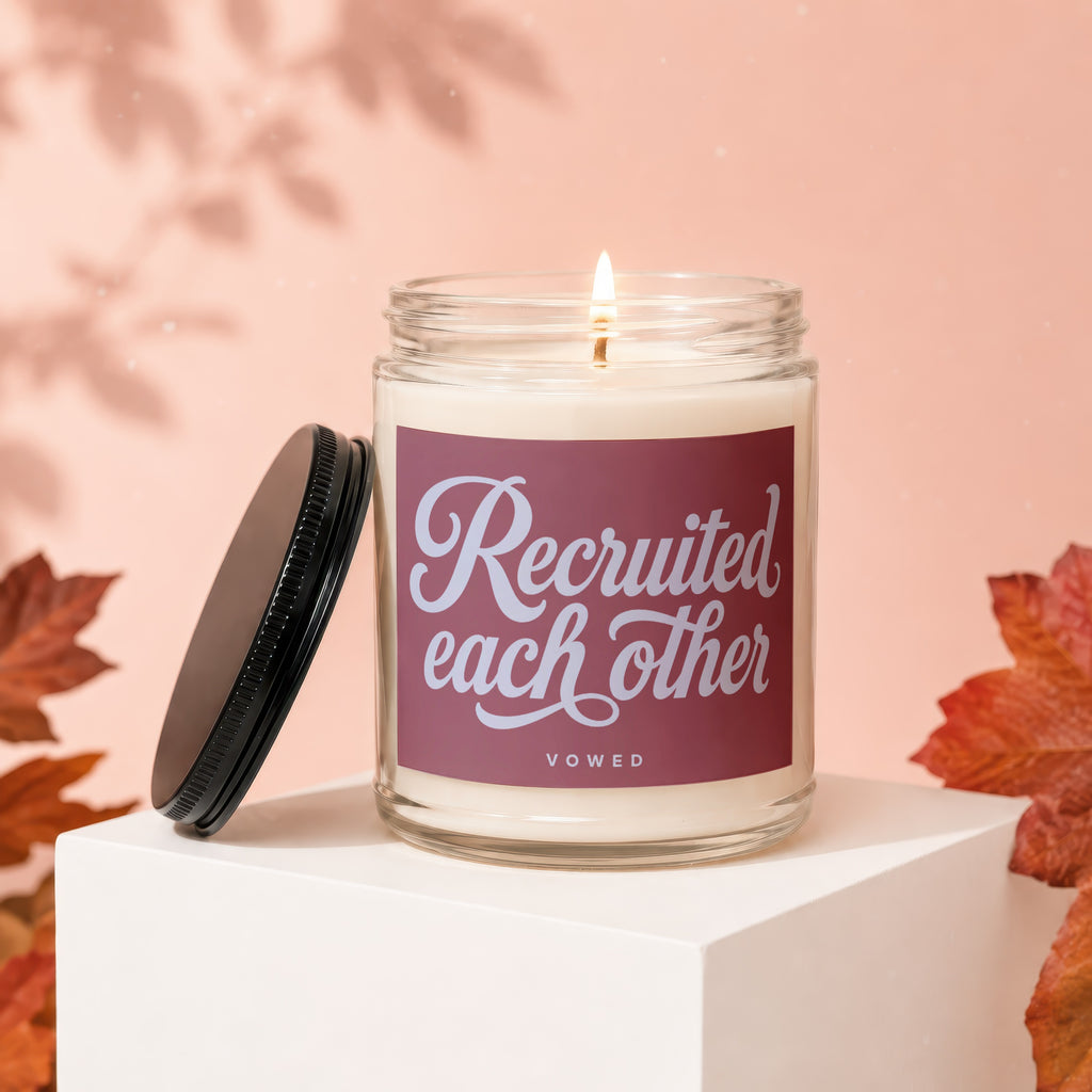 Candle with text "Recruited each other" and "VOWED" on a maroon label.