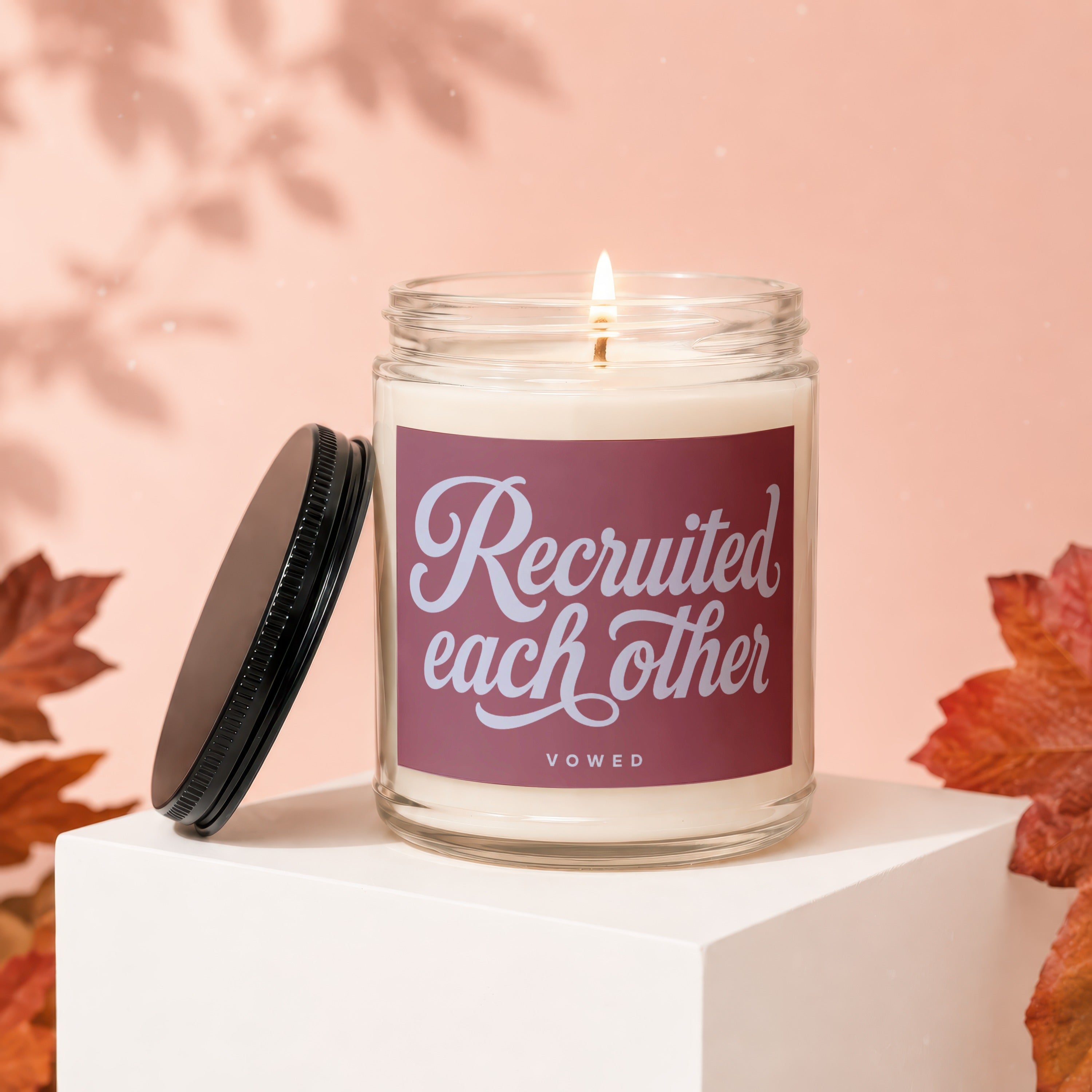 Candle with text "Recruited each other" and "VOWED" on a maroon label.